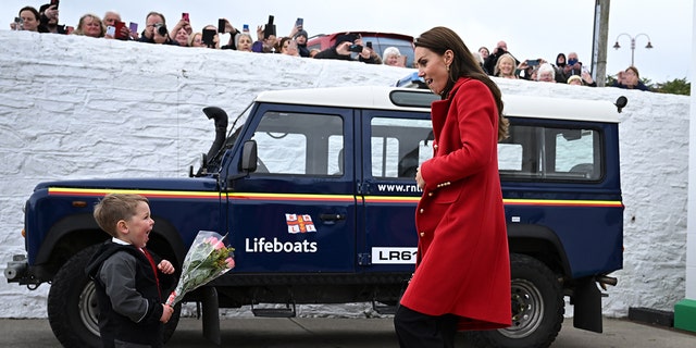 Catherine, Princess of Wales, is presented with flowers by 4-year-old Theo Crompton at the Royal National Lifeboat Institution's Holyhead Lifeboat Station in Holyhead, Wales on Sept. 27, 2022.