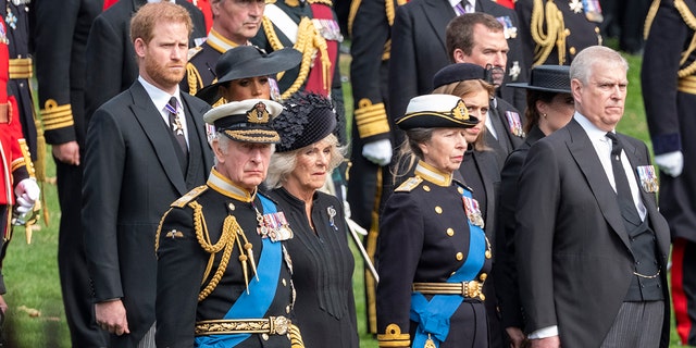 King Charles III, Camilla, Queen Consort, Princess Anne, Princess Royal, Prince Andrew, Duke of York, Princess Beatrice, Princess Eugenie, Peter Phillips, Prince Harry, Duke of Sussex, Meghan, Duchess of Sussex, watch as the coffin of the late Queen Elizabeth II arrives at Wellington Arch from Westminster Abbey on September 19, 2022 in London, England. 