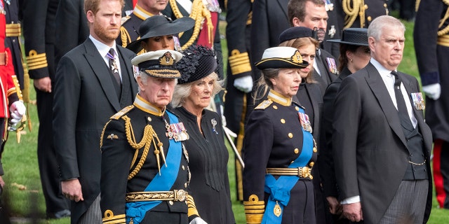 From left: Britain's King Charles III, Camilla, Queen Consort, Princess Anne, Princess Royal, Prince Andrew, Duke of York, Princess Beatrice, Princess Eugenie, Peter Phillips, Prince Harry, Duke of Sussex, Meghan, Duchess of Sussex, watch as the coffin of the late Queen Elizabeth II arrives at Wellington Arch from Westminster Abbey on Sept. 19, 2022, in London. 