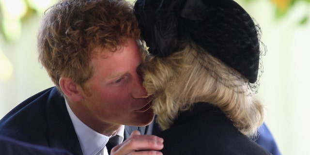 El príncep Harry saluda la reina consort Camilla (aleshores duquessa de Cornualla) mentre assisteixen a un servei d'acció de gràcies per a Gerald Ward, padrí del príncep Harry, a l'església de Santa Maria de Chilton Foliat, Anglaterra, el 3 d'octubre de 2008.