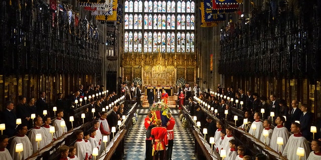 تابوت ملکه الیزابت دوم توسط حاملان شرکت ملکه، گردان اول نگهبانان نارنجک در طول خدمات متعهد به ملکه الیزابت دوم در کلیسای سنت جورج، قلعه ویندزور در 19 سپتامبر 2022 در ویندزور، انگلستان حمل می شود.