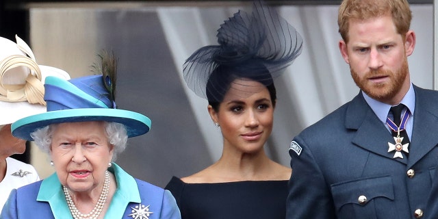 Queen Elizabeth II and the Duke and Duchess of Sussex on the balcony of Buckingham Palace as the royal family marks the centenary of the Royal Air Force on July 10, 2018, in London.