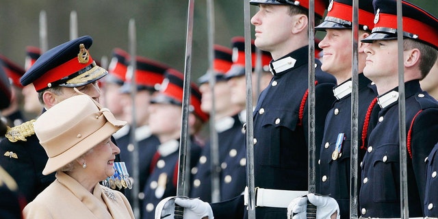 Karalienė Elžbieta II kaip išdidi močiutė šypsosi princui Harry, kai ji 2006 m. balandžio 12 d. apžiūri karius Sandhurst karo akademijoje Surėjaus mieste, Anglijoje.