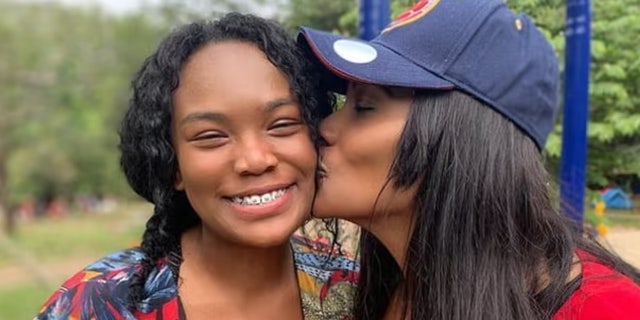 Salomé Jackson (right) gives her little sister, Giselle Rengifo, a kiss on the cheek.  Rengifo was shot in the head by Michael McGown in 2020.