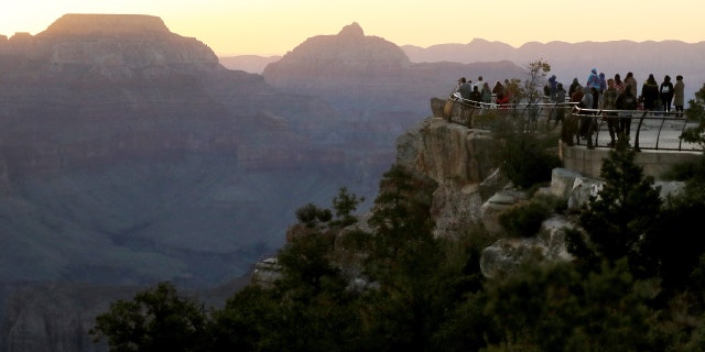 GRAND CANYON NATIONAL PARK, ARIZONA - MAY 25: Visitors gather for sunrise on Memorial Day along the South Rim of Grand Canyon National Park, which has partially reopened on weekends amid the coronavirus (COVID-19) pandemic, on May 25, 2020 in Grand Canyon National Park, Arizona. The park has opened for limited hours and access the past two weekends despite concerns that the mingling of visitors could contribute to the spread of the COVID-19 virus. Critics point out that the neighboring Navajo Nation is currently suffering the highest rate of COVID-19 infection in the nation per capita and some travelers would need to pass through the nation to arrive at the park.