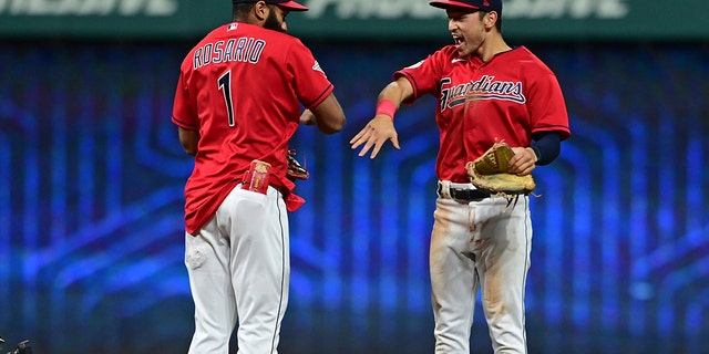 Cleveland Guardians left fielder Steven Kwan, right, and shortstop Amed Rosario celebrate after the Guardians defeated the Los Angeles Angels 3-1 in a baseball game Tuesday, Sept. 13, 2022, in Cleveland.