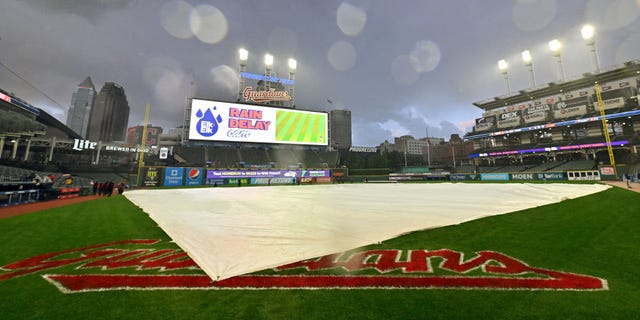 The tarp sits on the field after rain stopped play during the third inning of a game between the Tampa Bay Rays and the Cleveland Guardians at Progressive Field Sept. 27, 2022, in Cleveland.