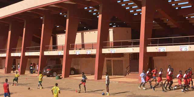 Football players train outside the Stadium in Conakry on Sept. 26, 2022, on the eve of the opening of the trial for the eleven men accused of being responsible for the massacre of over 150 protesters at the same stadium in 2009. 