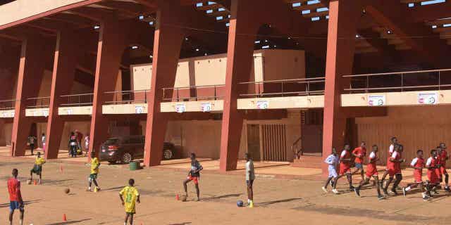 Football players train outside the Stadium in Conakry on Sept. 26, 2022, on the eve of the opening of the trial for the eleven men accused of being responsible for the massacre of over 150 protesters at the same stadium in 2009.