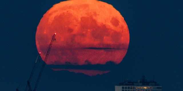 The full moon, also known as the harvest moon, rises above Birmingham, at sunset on Monday. Picture date: Monday September 20, 2021.