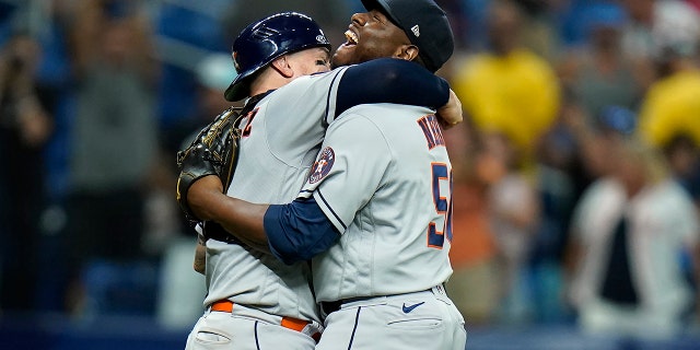 Houston Astros relief pitcher Hector Neris (50) hugs catcher Christian Vazquez after the team defeated the Tampa Bay Rays during a baseball game Monday, Sept. 19, 2022, in St. Petersburg, Fla.