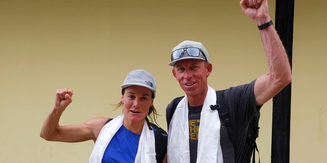 Hilaree Nelson of Telluride, Colorado, and Jim Morrison of Tahoe, California, raise their fists as the pair arrived in Kathmandu, Nepal, on Oct. 4, 2018.