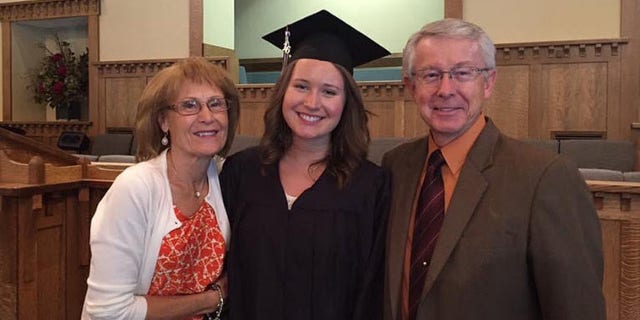 The Gaddy family's second homeschooled graduate smiles in cap and gown as she shares graduation day with her grandparents.