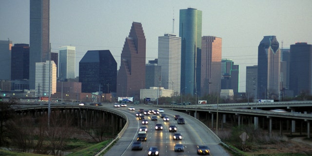 The Houston skyline at dusk and I-45 commuter traffic.