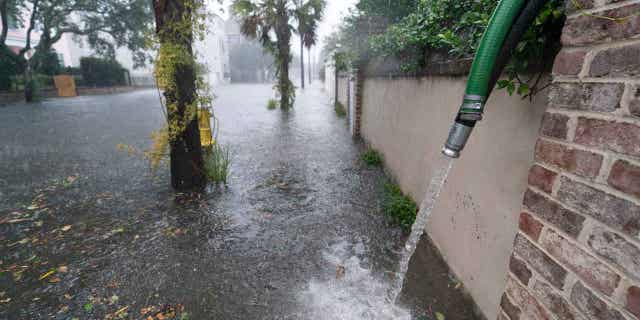 Residents use pumps to remove water from around their homes as the effects of Hurricane Ian are felt in Charleston, South Carolina, on Sept. 30, 2022.