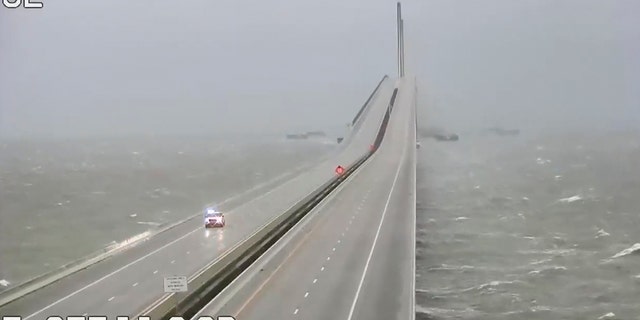 This image provided by FLDOT shows an emergency vehicle traveling on the Sunshine Skyway over Tampa Bay, Fla., on Wednesday. 