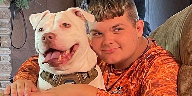 Walker Cousineau, a ninth-grade student, relaxes at home with Dave, his newly adopted dog. Walker is 14 and is experiencing hearing loss caused by a kidney disorder. Dave, his pit bull, is deaf.
