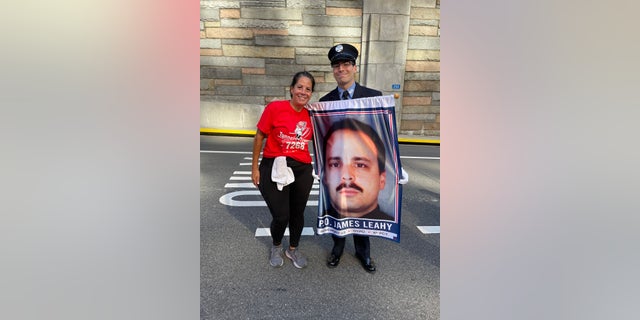 Marcela Leahy with her son, John, holding an image of her fallen 9/11 hero husband, James Leahy