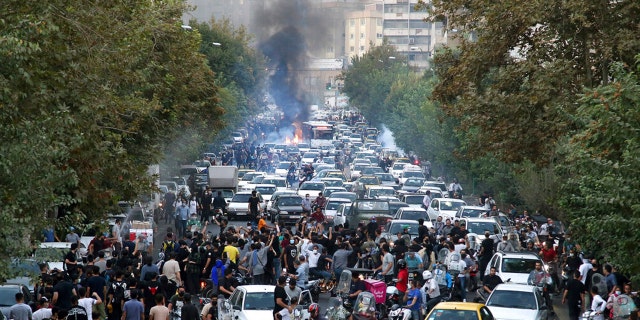 Demonstrators chant slogans during a protest in downtown Tehran, Iran, over the death of a woman who was detained by the morality police.