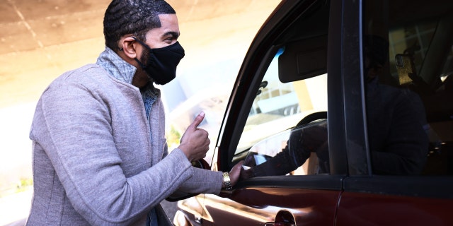 Mayor Chokwe Antar Lumumba gives a thumbs up to a resident at a drive-thru food bank at the Russell C. Davis Planetarium sponsored by the Greater Jackson Arts Council and Reuben V. Anderson Center for Justice Lead Partnership on March 6, 2021, in Jackson, Mississippi.