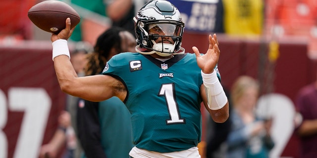 El mariscal de campo de los Philadelphia Eagles, Jalen Hurts (1), patea el balón antes del comienzo de un partido de fútbol americano de la NFL contra los Washington Commanders, el domingo 25 de septiembre de 2022, en Landover, Maryland. 