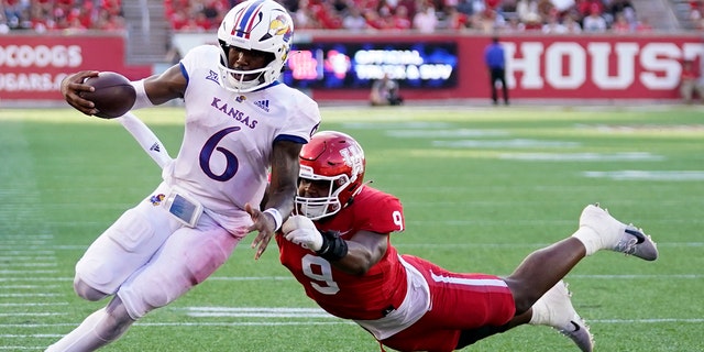 Kansas Jayhawks quarterback Jalon Daniels escapes a tackle from Cougars defensive lineman Nelson Ceaser en route to a touchdown on Saturday, September 1.  17, 2022, in Houston.