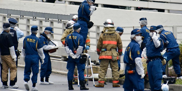 Police and firefighters inspect the scene where a man is reported to set himself on fire, near the Prime Minister's Office in Tokyo, Wednesday, Sept. 21, 2022.