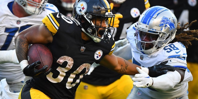 Jaylen Warren, #30 of the Pittsburgh Steelers, takes the ball in front of #59 James Houston of the Detroit Lions during the fourth quarter at Acrisur Stadium on August 28, 2022 in Pittsburgh.