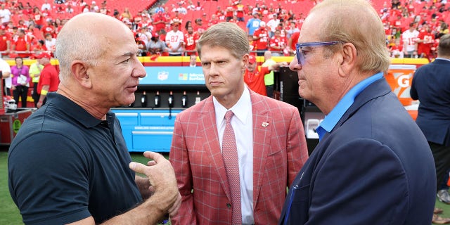 From left, Amazon founder Jeff Bezos talks with Kansas City Chiefs owner Clark Hunt and Los Angeles Chargers owner Dean Spanos on the field before the game at Arrowhead Stadium in Kansas City, Missouri, on Thursday.