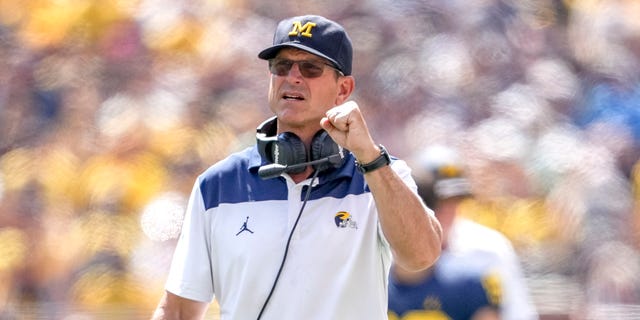 Michigan Wolverines head coach Jim Harbaugh punches the Colorado State Rams during the first half at Michigan Stadium on September 3, 2022 in Ann Arbor, Michigan.