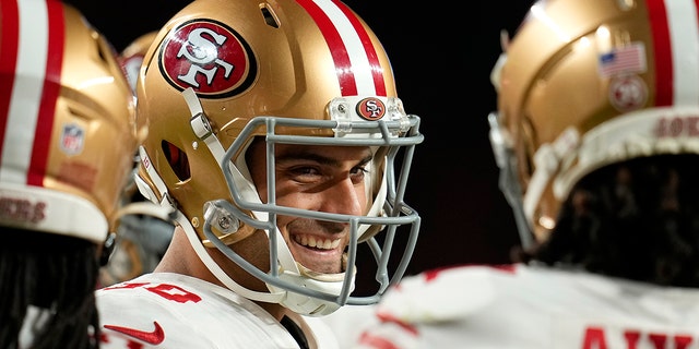 San Francisco 49ers quarterback Jimmy Garoppolo smiles in the huddle during the first half of an NFL football game against the Denver Broncos in Denver, Sunday, Sept. 25, 2022.