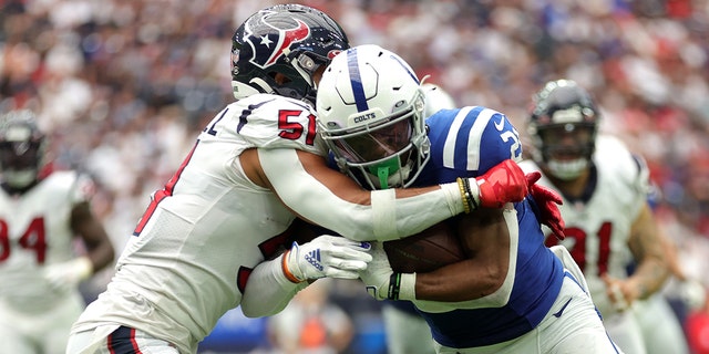Camu Grugier-Hill (51) of the Houston Texans tries to tackle Jonathan Taylor of the Indianapolis Colts at NRG Stadium in Houston on September 11, 2022.