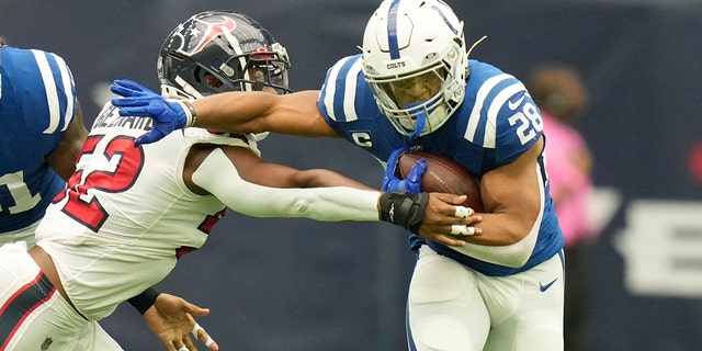 The Indianapolis Colts beat Jonathan Taylor (28) to the hard-arms Houston Texans' defensive end Jonathan Greenard (52) during the first half of September 11, 2022 in Houston.