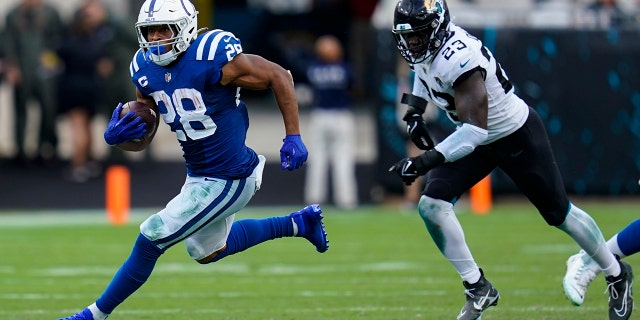 Indianapolis Colts running back Jonathan Taylor (28) get past Jacksonville Jaguars linebacker Foyesade Oluokun (23) for a gain during the second half of an NFL football game, Sunday, Sept. 18, 2022, in Jacksonville, Fla.