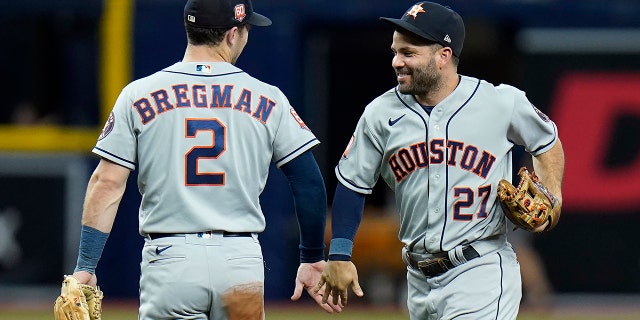 Houston Astros second baseman Jose Altuve (27) celebrates with third baseman Alex Bregman (2) after defeating the Tampa Bay Rays during a baseball game Monday, Sept. 19, 2022, in St. Petersburg, Fla.