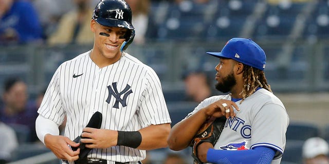 Aaron Judge de los Yankees de Nueva York, a la izquierda, en acción contra Vladimir Guerrero Jr. de los Blue Jays de Toronto en el Yankee Stadium el 13 de abril de 2022 en la ciudad de Nueva York.  