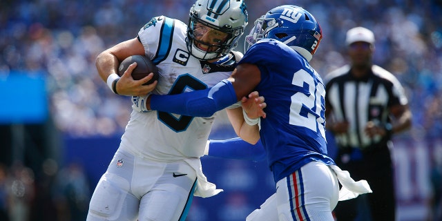 New York Giants' Julian Love, right, tries to tackle Carolina Panthers quarterback Baker Mayfield during the first half an NFL football game, Sunday, Sept. 18, 2022, in East Rutherford, New Jersey.