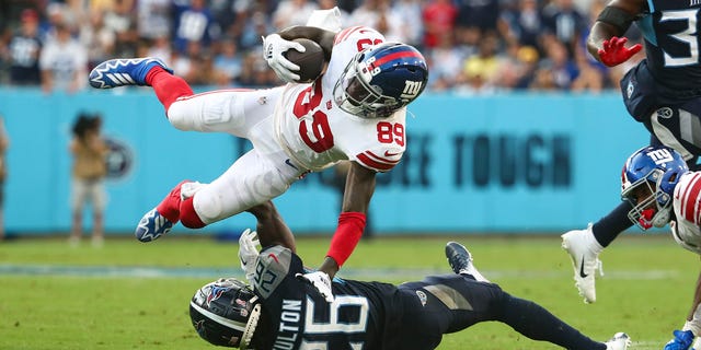 Kristian Fulton, #26 of the Tennessee Titans, tackles Kadarius Toney, #89 of the New York Giants, during an NFL football game at Nissan Stadium on September 11, 2022, in Nashville, Tennessee.