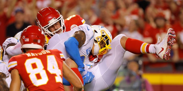 Derwin James Jr. of the Los Angeles Chargers tackles Travis Kelce of the Kansas City Chiefs during the third quarter at Arrowhead Stadium in Kansas City on Sept. 15, 2022.