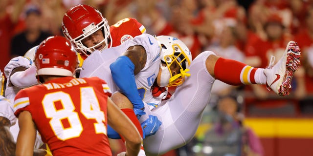 Derwin James Jr. of the Los Angeles Chargers tackles Travis Kelce of the Kansas City Chiefs during the third quarter at Arrowhead Stadium in Kansas City on Sept. 15, 2022.