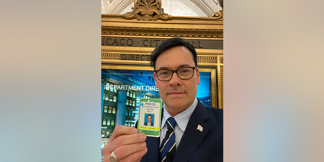 Chicago reporter William J. Kelly holds up his press credential with a June 2024 expiration but was denied access to Lightfoot's press conference by Chicago police, alleging his press credential had expired.