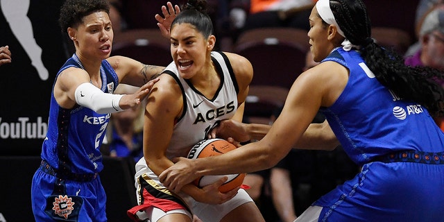 Connecticut Sun's Natisha Hiedeman, left, and Brionna Jones, right, pressure Las Vegas Aces' Kelsey Plum during the first half in Game 3 of basketball's WNBA Finals on Thursday, Sept. 15, 2022, in Uncasville, Conn. 