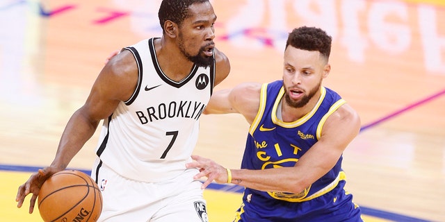 Brooklyn Nets forward Kevin Durant is defended by Golden State Warriors guard Stephen Curry at Chase Center, Feb. 13, 2021, in San Francisco.