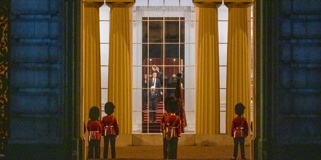 King Charles III, Prince Harry, Duke of Sussex, and Meghan, Duchess of Sussex, wait for the Royal Hearse carrying the coffin of Queen Elizabeth II to arrive at Buckingham Palace.