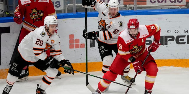 FILE - Kunlun Red Star's Ryan Sproul, right, of Canada, fights for the puck with Amur's Radan Lenc, left, during the Kontinental Hockey League ice hockey match between Kunlun Red Star Beijing and Amur Khabarovsk in Mytishchi, just outside Moscow, Russia, on Nov. 15, 2021. North Americans playing in the Russia-based KHL have been put in a difficult position amid calls from the U.S and Canadian governments for them to leave the country because of the war in Ukraine.