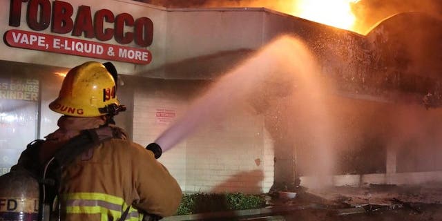 A Los Angeles firefighter is seen battling a fire in the Palms area of Los Angeles early September 17, 2022.