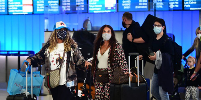 (file photo) Travelers arrive in the international terminal at Los Angeles International Airport on December 3, 2021.