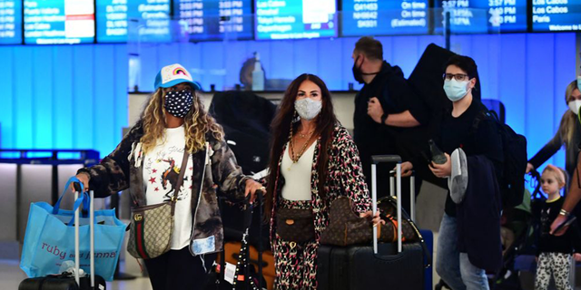 (file photo) Travelers arrive in the international terminal at Los Angeles International Airport on December 3, 2021.