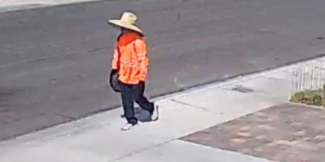 The possible suspect in journalist Jeff German's stabbing death is pictured wearing a bright orange jacket and large hat.