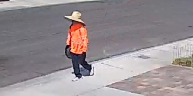 The possible suspect in journalist Jeff German's stabbing death is pictured wearing a bright orange jacket and large hat.